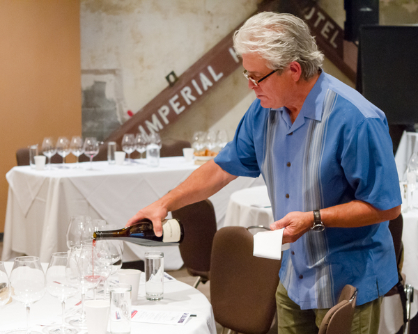 Ken Wright, founding winemaker of Panther Creek Cellars, pours 20-year-old Pinot Noir made from Carter Vineyard, during a celebration at the Imperial Hotel in Portland. (Photo by Chris Bidelman/Courtesy of Bacchus Capital Management)